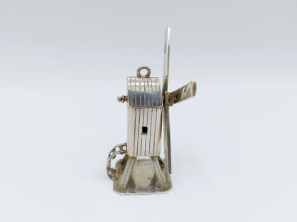 Zilveren miniatuur windmolen met slanke as en metalen basis.