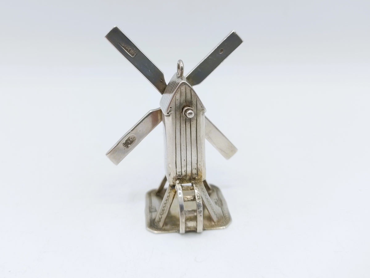 Zilveren miniatuur windmolen met vier wieken en ronde middenplaat.