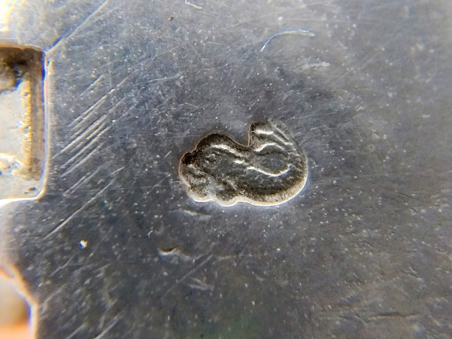 Gegraveerd keurmerk op zilveren metalen windmolenbasis.