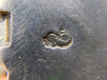 Gegraveerd keurmerk op zilveren metalen windmolenbasis.