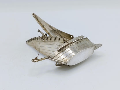 Zilveren miniatuurzeilschip met boeg en kettingdetail, driekwart zijaanzicht