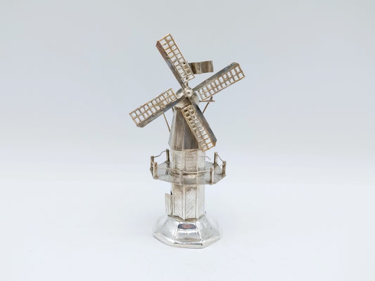 Miniatuur stellingmolen van zilverkleurig met opengewerkte wieken op ronde sokkel.