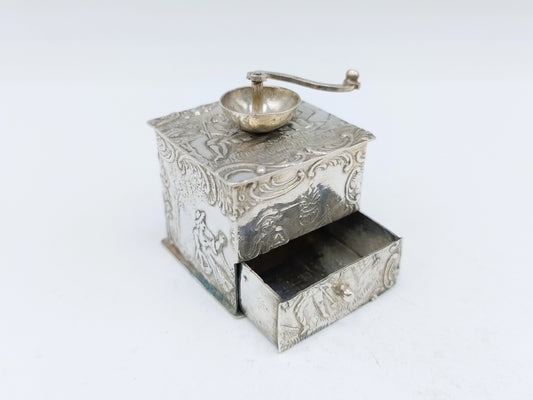 Zilveren miniatuur koffiemolen met open lade en maalbak bovenop