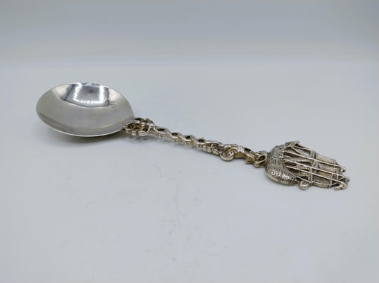Zilveren sierlepel met ketting en scheepsvormig hangertje aan het uiteinde