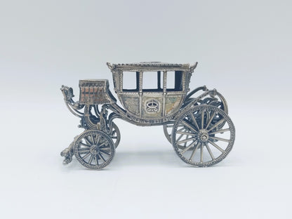 Zilverkleurige miniatuurkoets met open rijtuig en vier sierlijke wielen