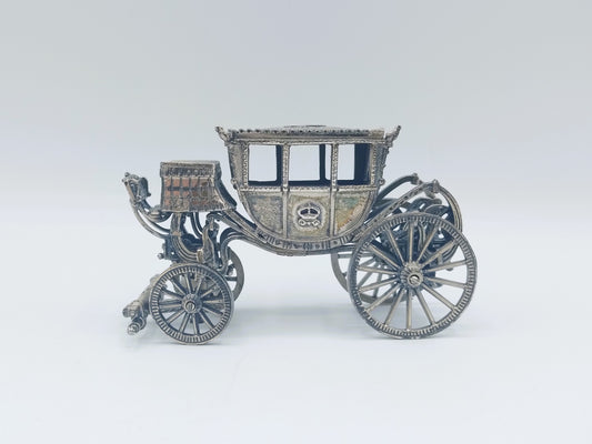 Zilverkleurige miniatuurkoets met open rijtuig en vier sierlijke wielen