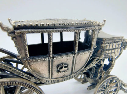 Zilverkleurige miniatuurkoets close-up: open ramen, gegraveerde carrosserie en wielen
