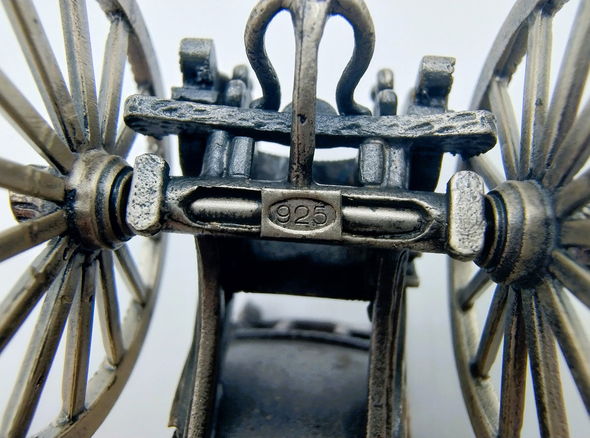 Detail van zilverkleurige miniatuurkoets wielassen met stempel “925”