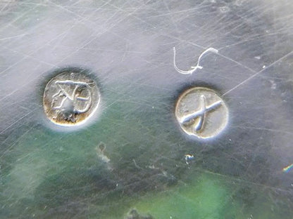 Gegraveerde symbolen op zilveren metalen plaat