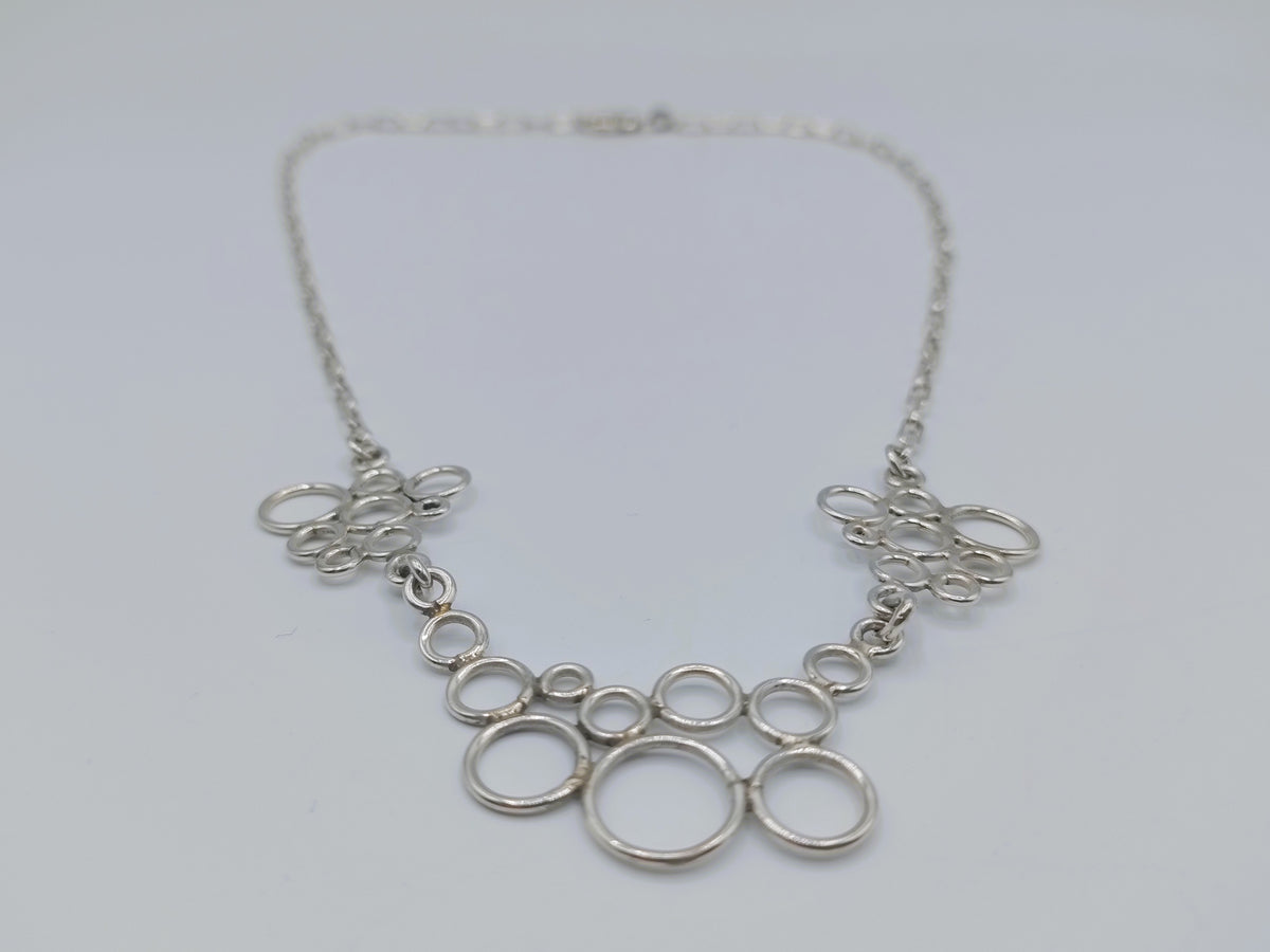 Zilveren ketting met decoratieve ringcollier en opengewerkte hangers