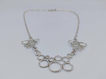 Zilveren ketting met decoratieve ringcollier en opengewerkte hangers