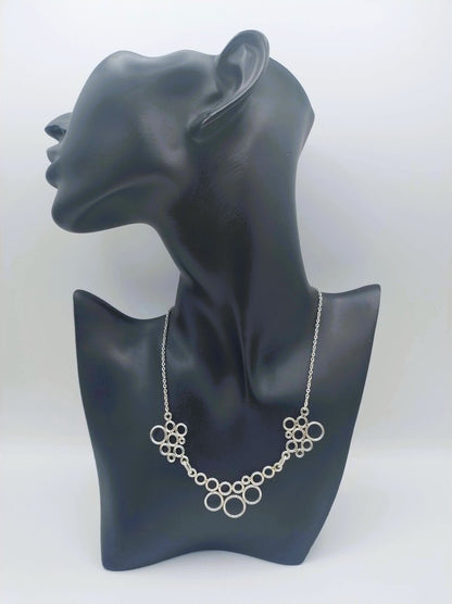 Zilveren designketting met ringvormige schakels op paspop