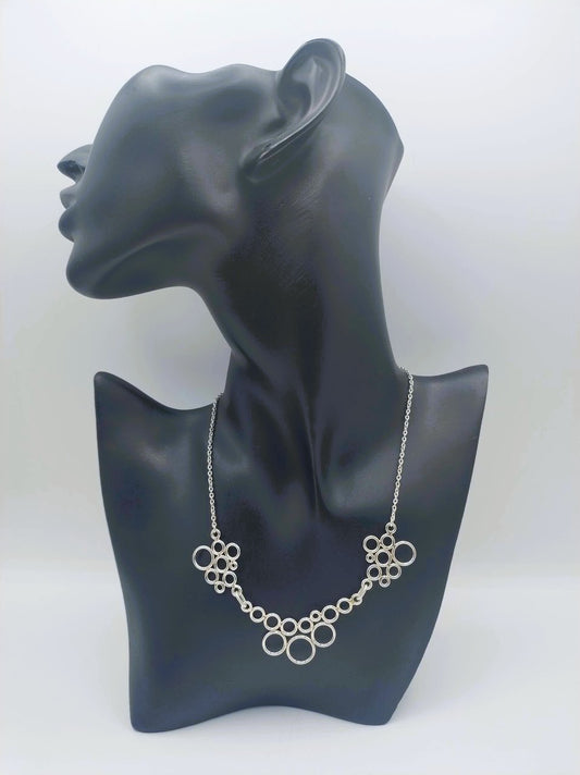 Zilveren designketting met ringvormige schakels op paspop