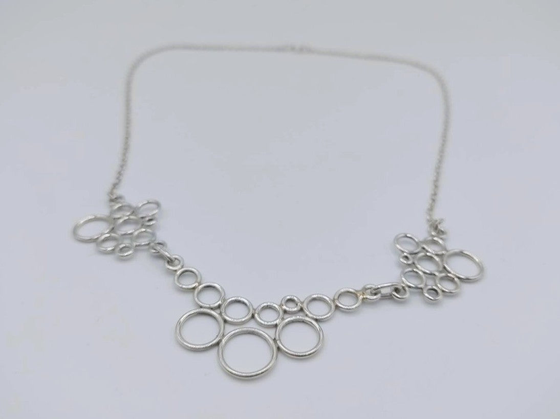 Zilveren designketting close-up: ringvormige schakels met open cirkelvormen