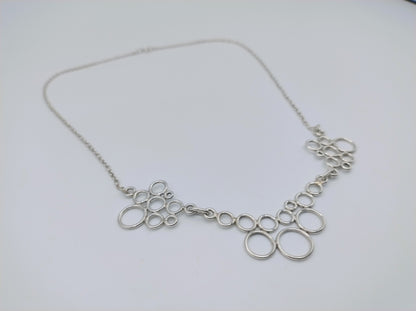 Zilveren ketting met ringvormige schakels, plat op witte ondergrond