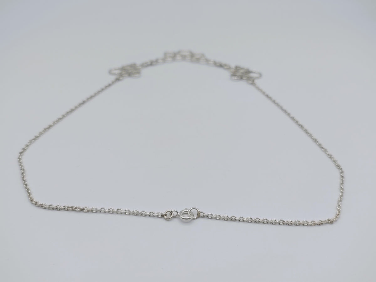 Zilveren ketting in beeld: fijne schakelketting met centrale ringvormige hanger