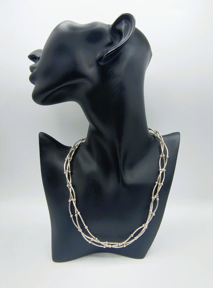 Zilveren designketting met drie rijen kettingschakels, als set op sierstandaard.