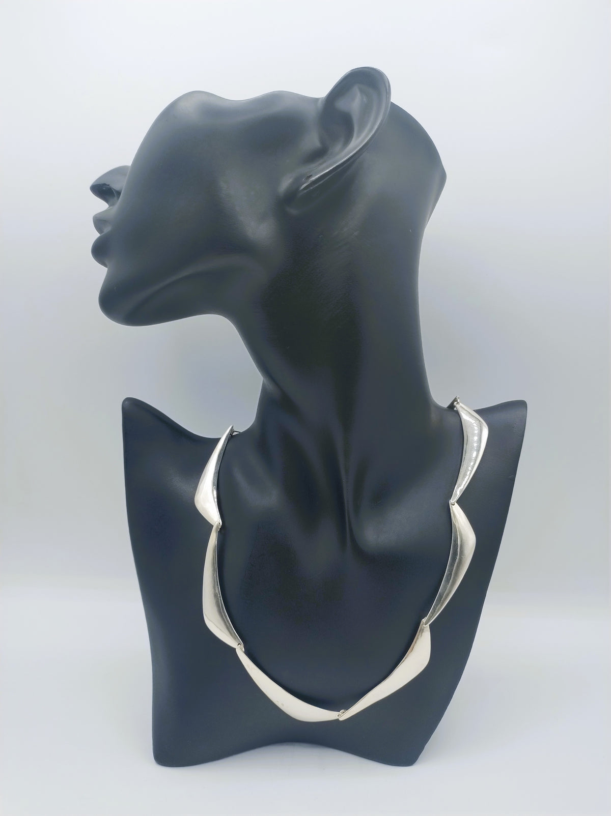 Zilveren designcollier op borstvorm: choker met golvende, driehoekige plaatjes
