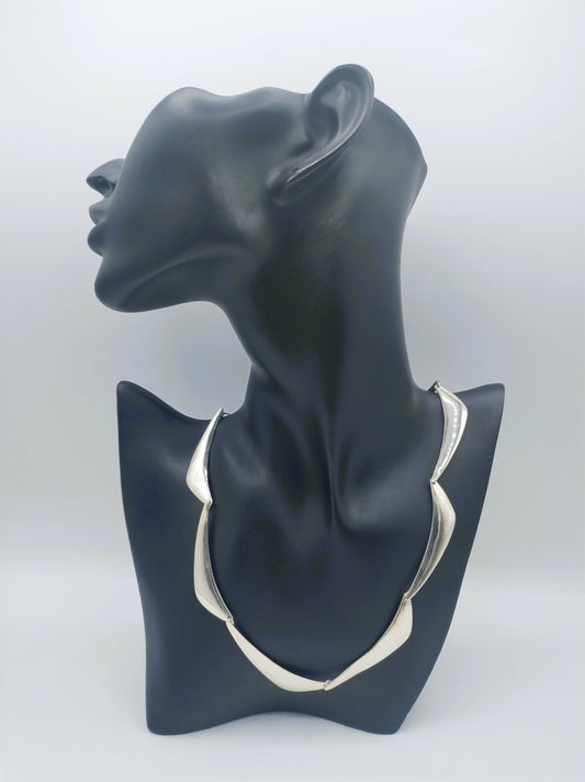 Zilveren designcollier op borstvorm: choker met golvende, driehoekige plaatjes