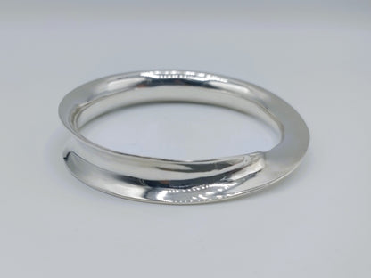 Zilveren bangle armband, voorkant met glanzende, licht opstaande rand