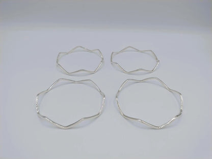 Vier zilverkleurige stervormige armbanden, losse bangle-stukken