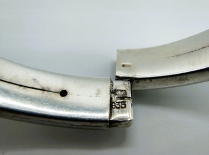Close-up van zilveren armband sluiting met keurmerk 835