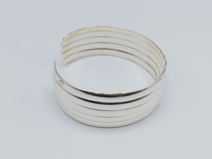 Zilveren cuff armband met golfmotief; meerdere horizontale groeven op de band.