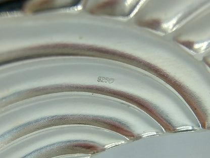 Close-up van zilveren armband met keurmerk “925” op het metaal.