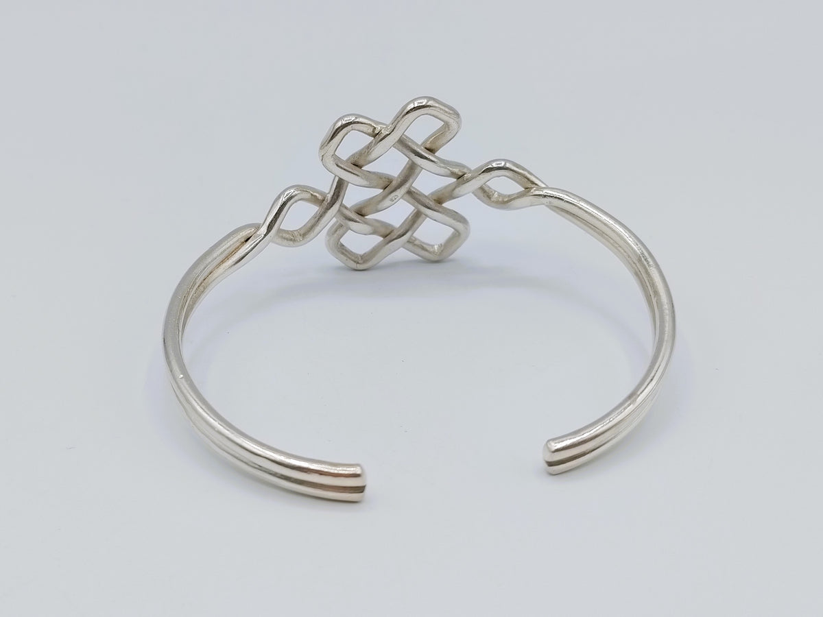 Zilveren armband met keltische knoop, close-up op open manche en centrale gevlochten verbinding