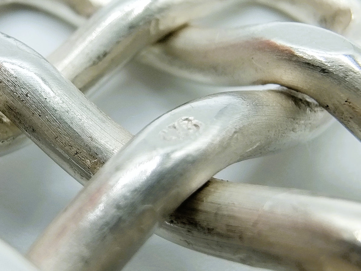 Zilveren keltische knoop, close-up van gevlochten rechthoekige schakels