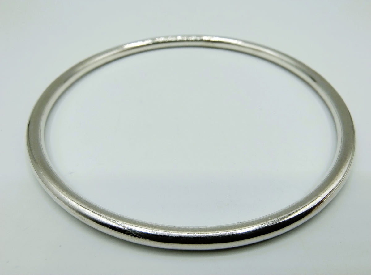 Zilveren slavenarmband close-up, gladde ovale ring met strakke afwerking