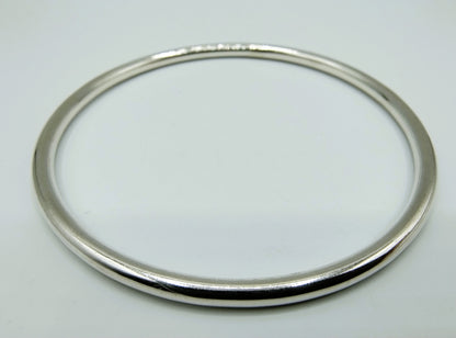 Zilveren slavenarmband close-up, gladde ovale ring met strakke afwerking