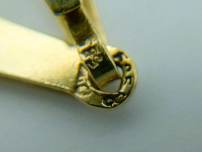Detail van sluiting en hangerbevestiging op gouden kruishanger, met reliëf