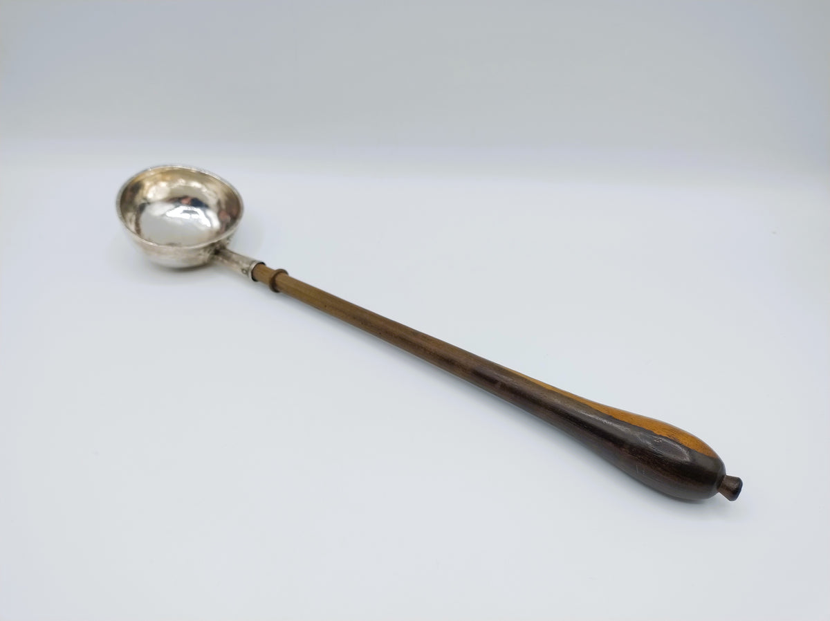 Zilveren punchlepel met houten steel en ronde metalen kop