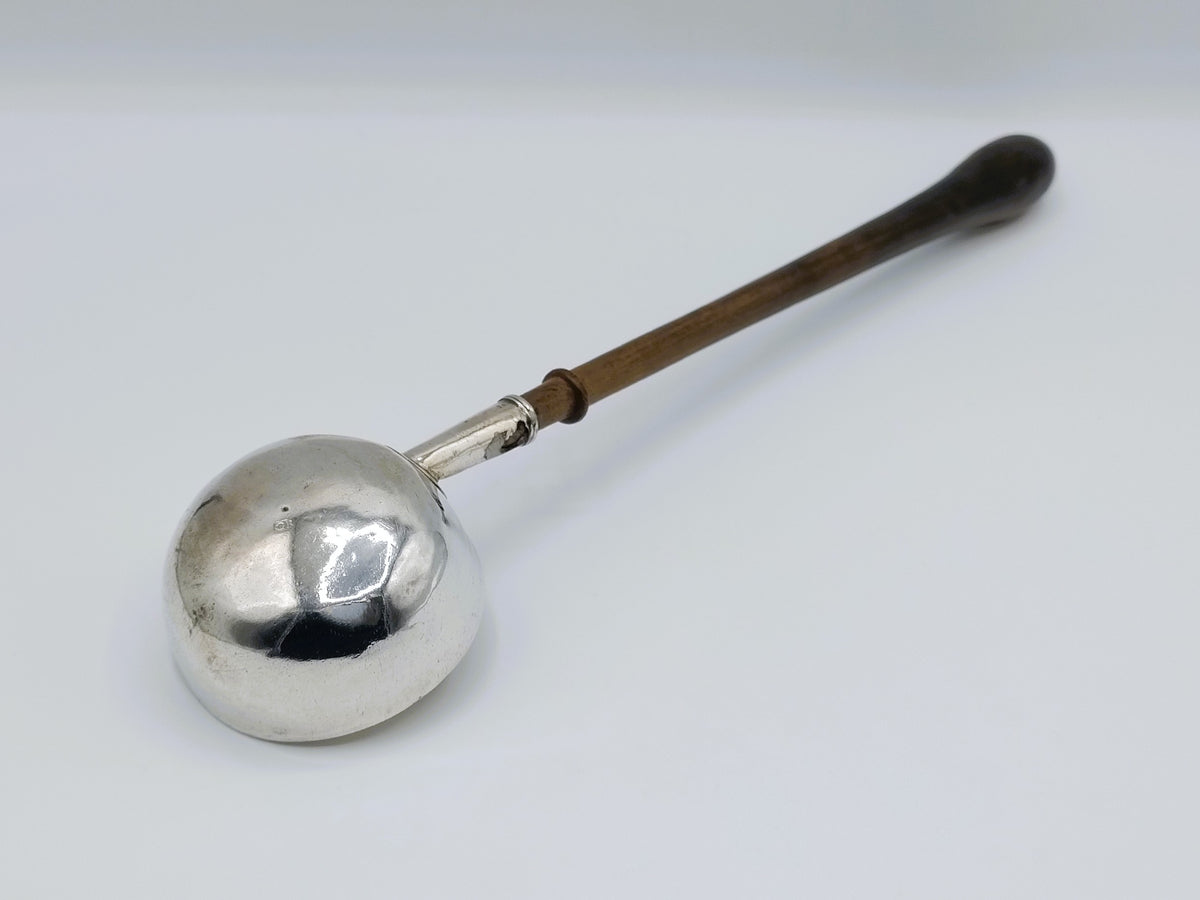 Zilveren punchlepel met ronde kom en houten steel, close-up