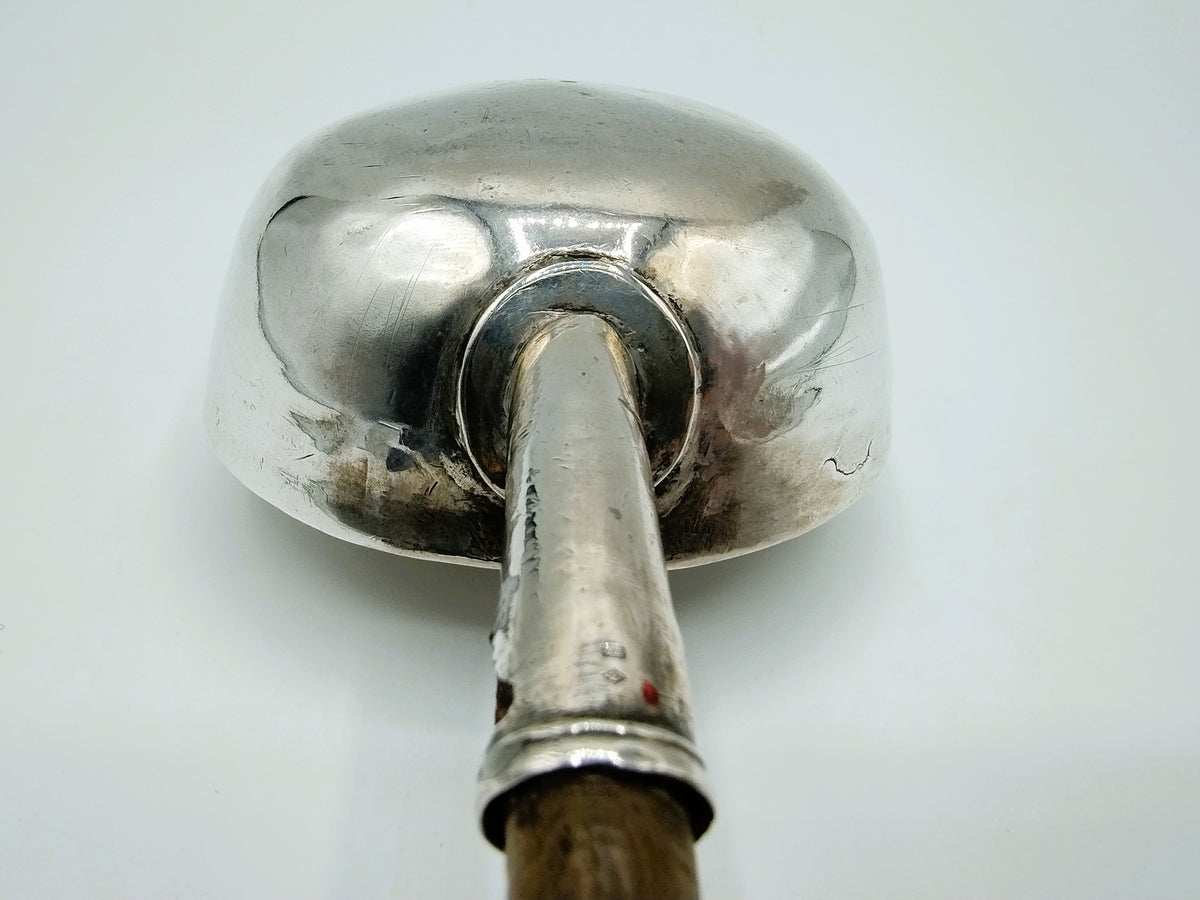 Zilveren punchlepelkop met bevestiging en donkere rand aan de steel