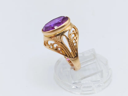 Gouden ring met paarse amethist in ovale zetting en opengewerkte zijpanelen