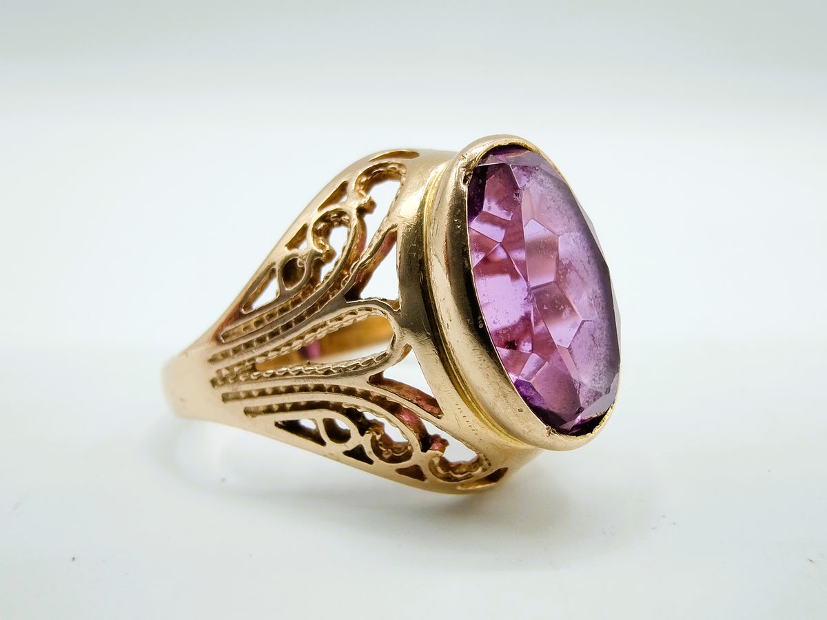Gouden ring met grote paarse amethist in ovale kast en gegraveerde band
