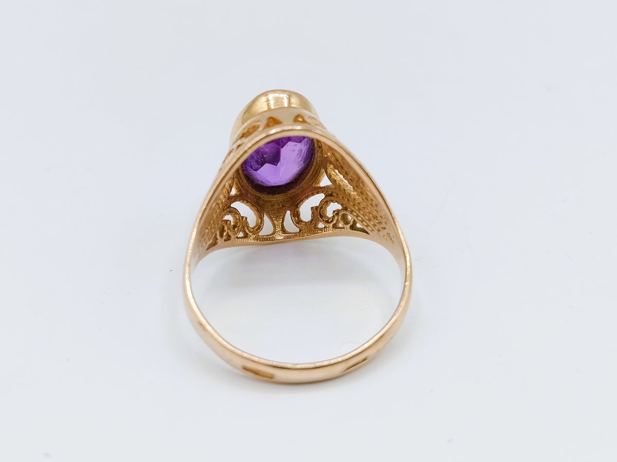 Gouden ring, achteraanzicht met ronde paarse steen in hoge zetting