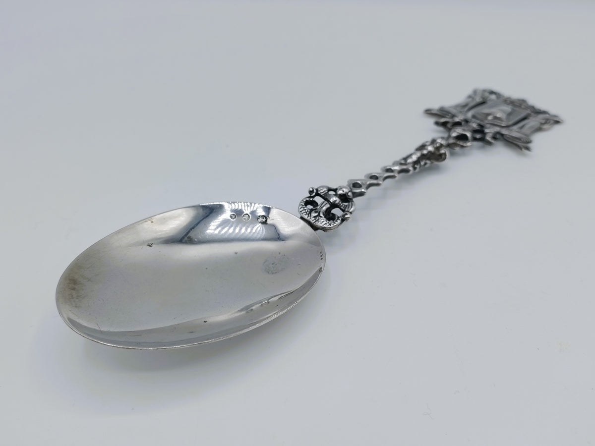 Zilveren lepel met ovale kom, schakelketting en gegraveerd decor aan het uiteinde