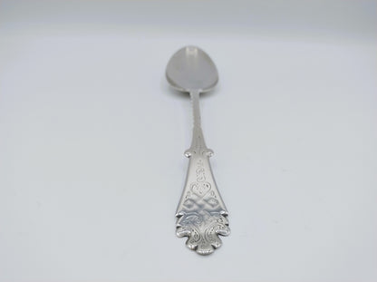 Zilveren lepeldetail met rond knopje, gegraveerde steel en decoratieve onderkant