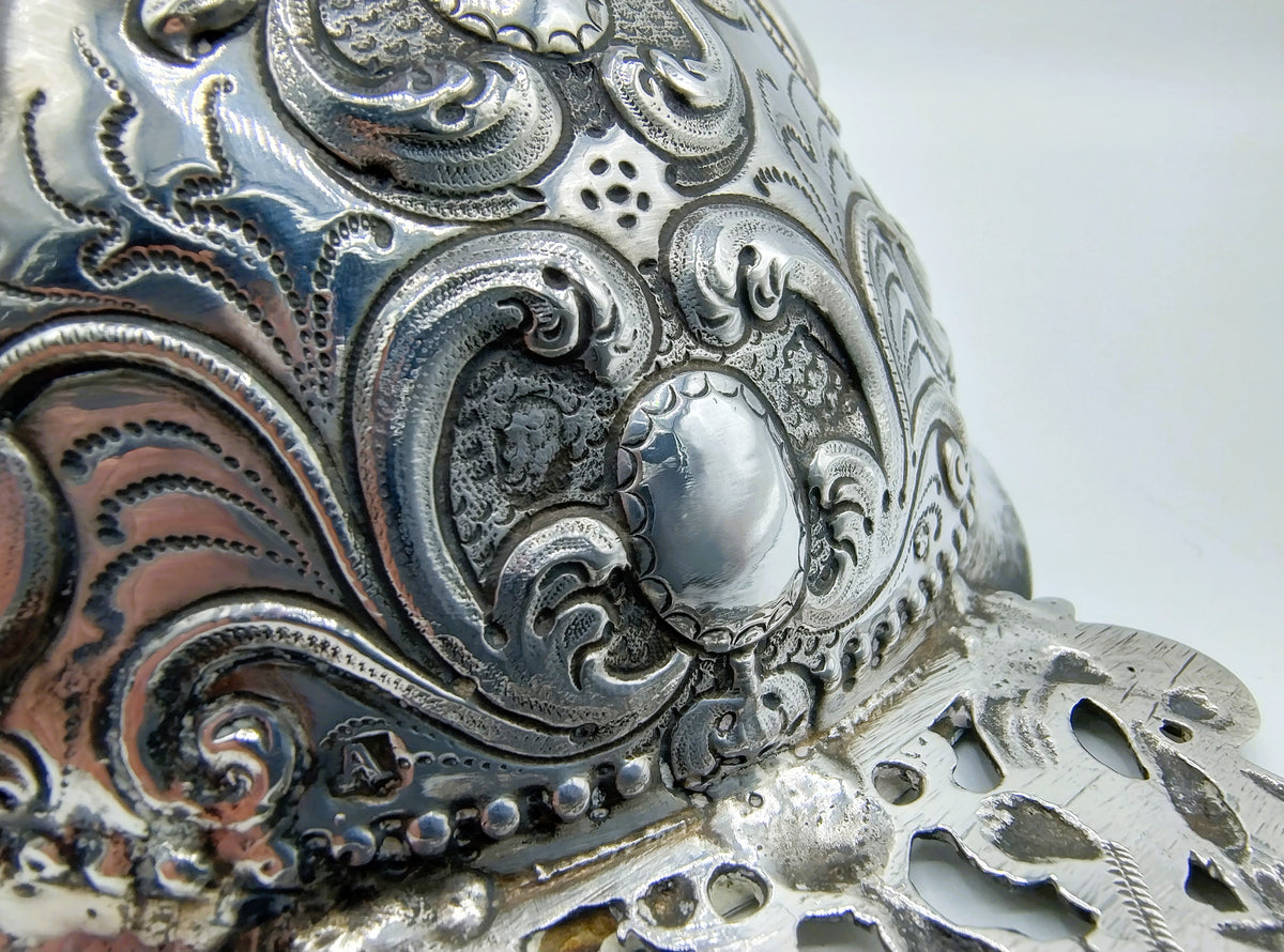 Detail van gegraveerde zilveren ornamenten rond een ovaal centraal vlak
