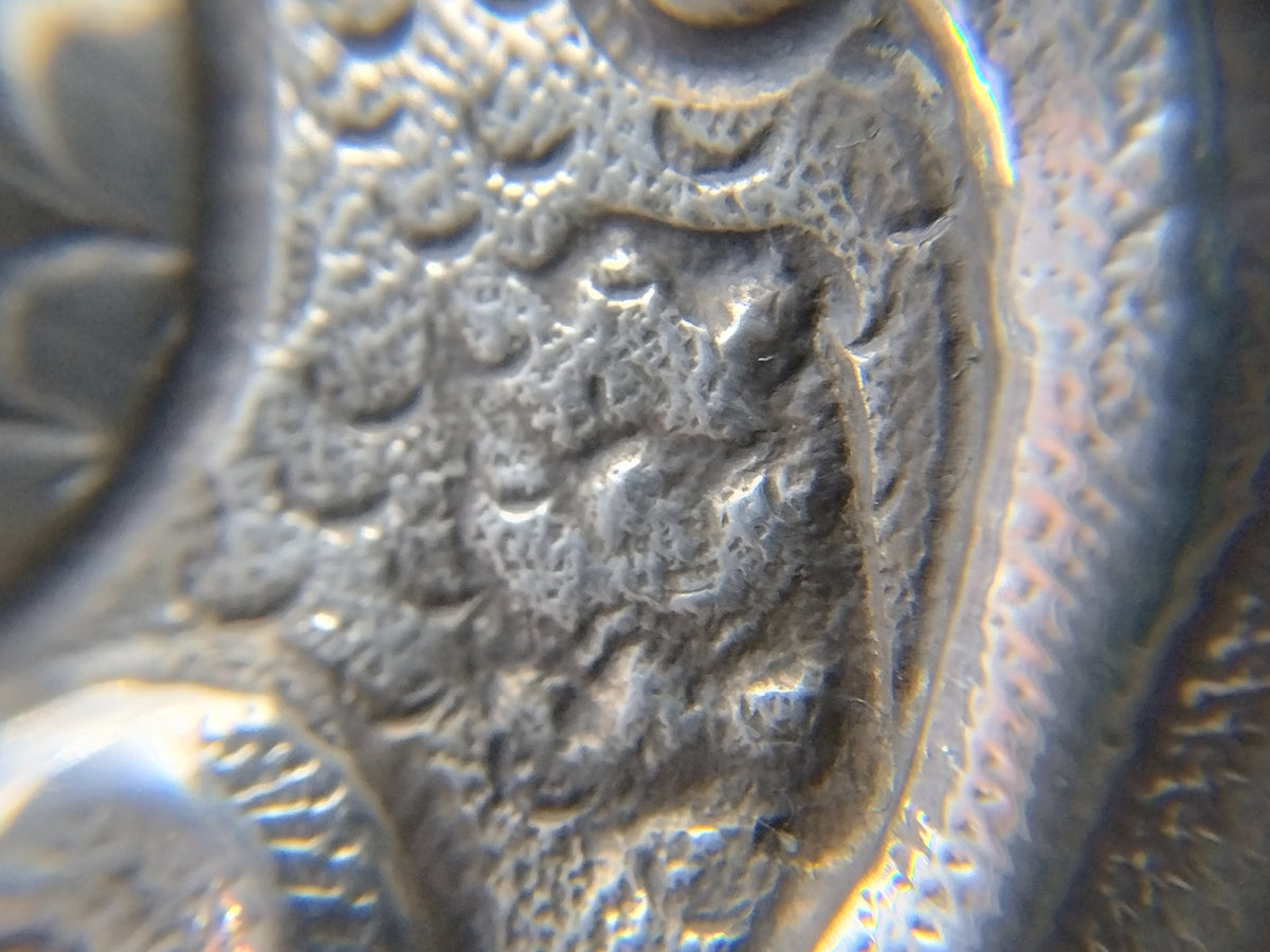 Close-up van reliëfgravure op zilveren brandewijnkom, met decoratief patroon