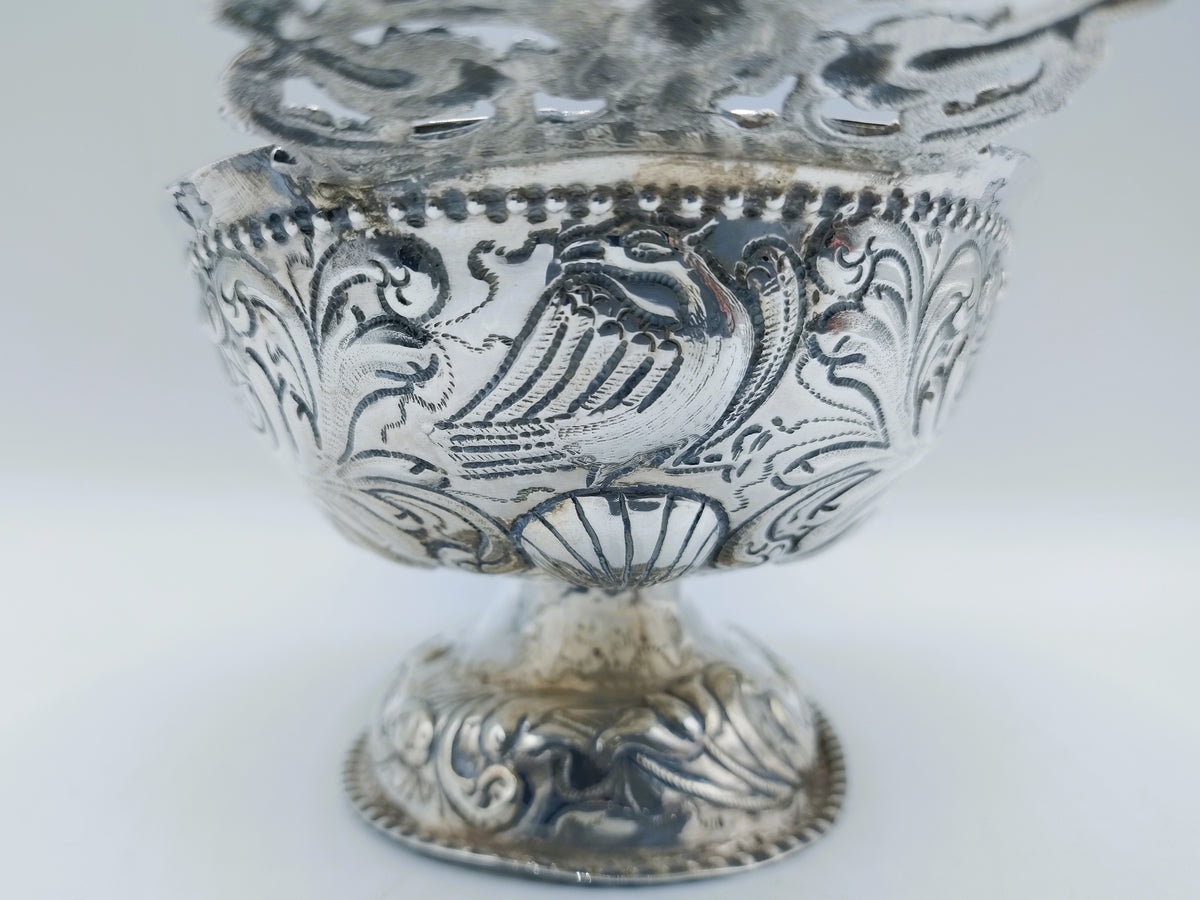 Zilveren brandewijnkom met gegraveerd bloemen- en figuurmotief op de voet
