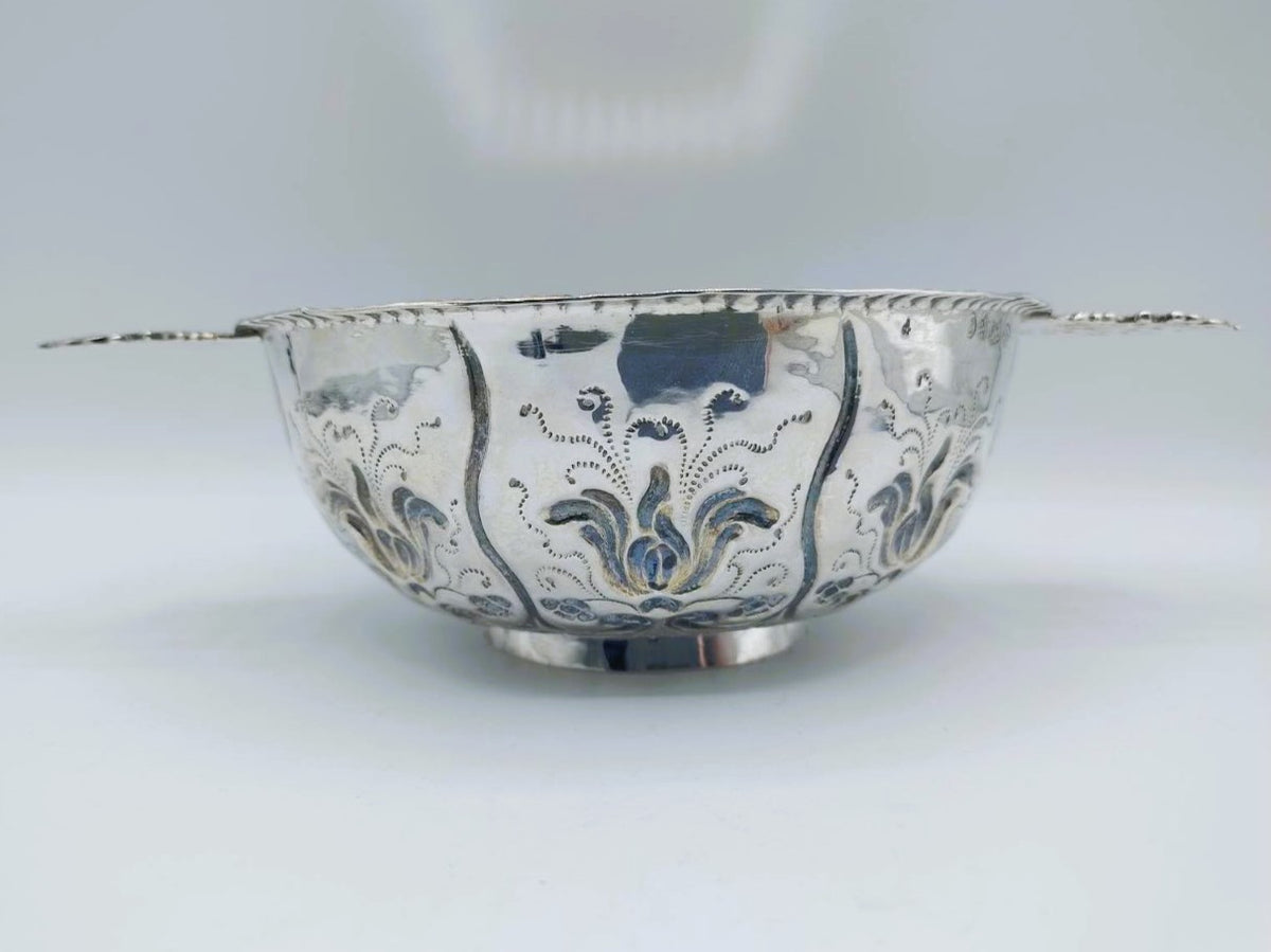 Zilveren brandewijnkom met brede rand en blauw-zwart gegraveerd ornament