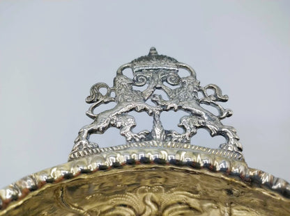 Zilveren randdecor met ornament en opstaande bogen boven de kom