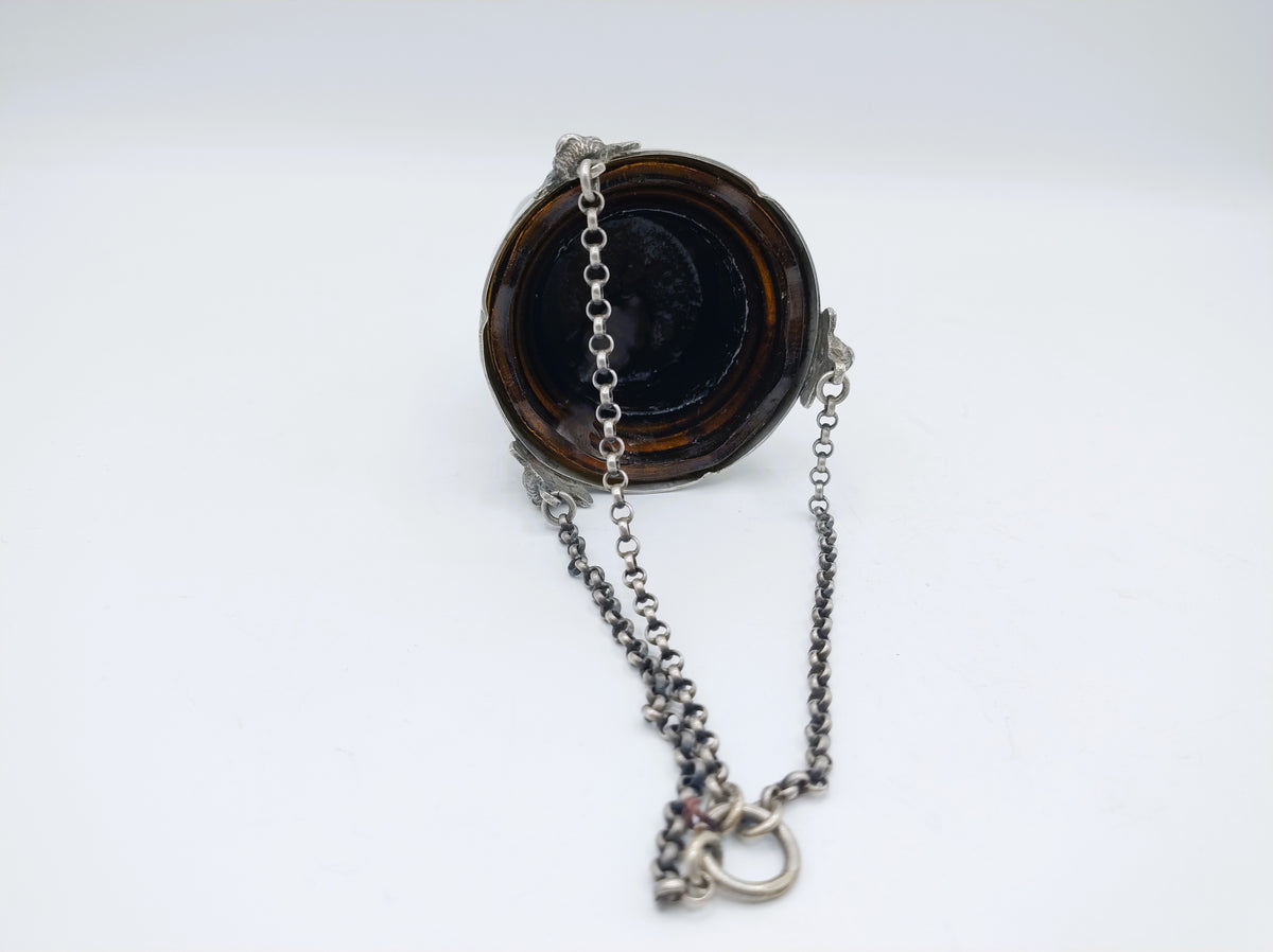 Zilveren altaarlamp met ketting en donkere glazen binnenbak.