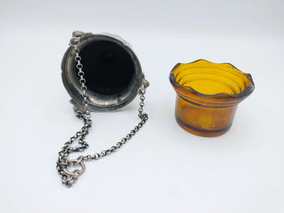 Zilveren altaarlamp met donkere glazen houder en amberkleurig glazen bakje.