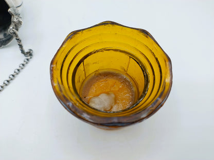 Amberkleurige glazen bak met glanzende binnenbodem en lichte vlekken.
