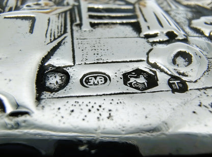 Kledingborstel: close-up van zilveren gegraveerd detail met kleine merktekens